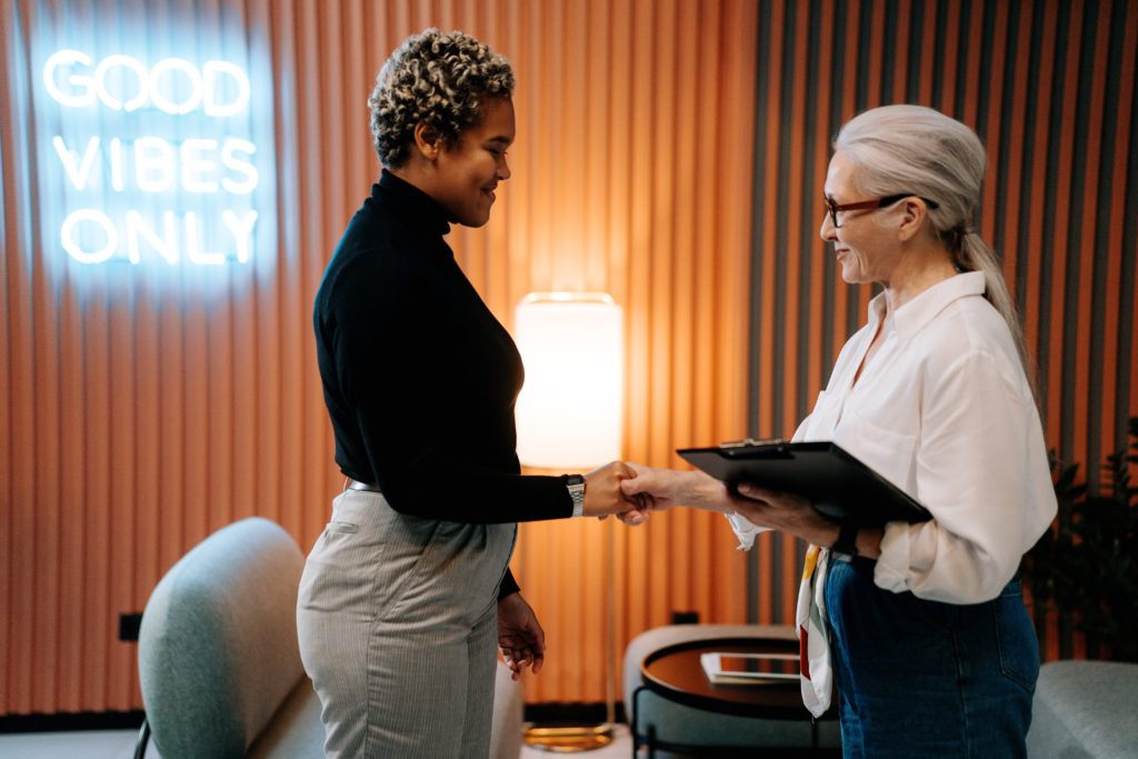two women shaking hands as HR trends change the job landscape for 2022 and beyond