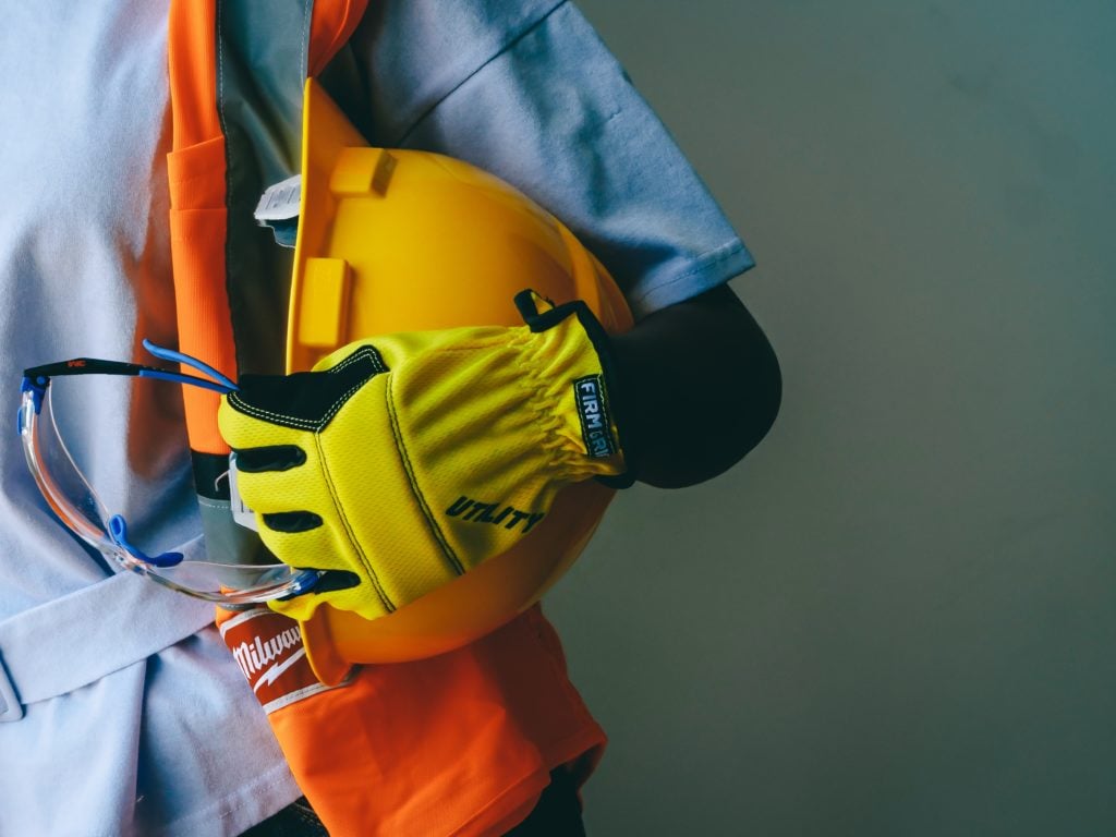 Person holding a hard hat thinking about starting an HVAC business