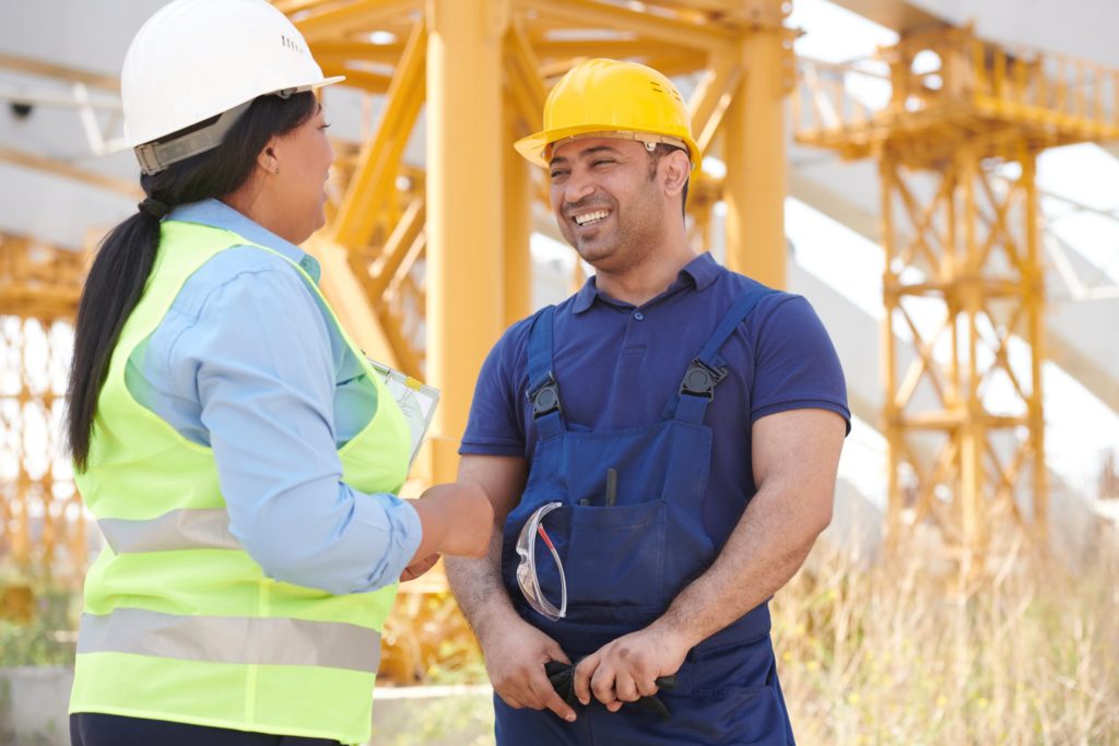 Two workers engaging in communication in construction site