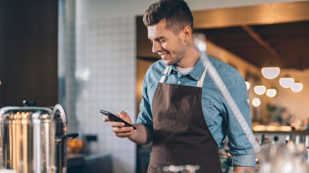 A barista uses an instant messaging app while at work