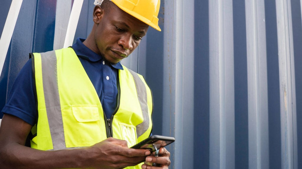 A construction worker uses an instant messaging app while at work