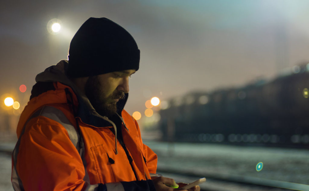 A night worker in a train yard finishes part of a split shift