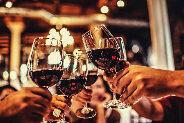 A stock photograph of five wine glasses held together in a “cheers” fashion.