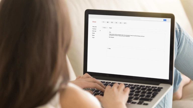 A female employee writes a PTO request email on a laptop