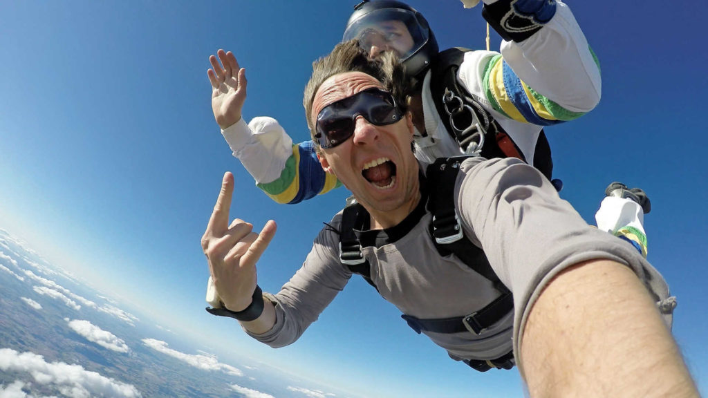 A man shows his excitement during a tandem parachute jump