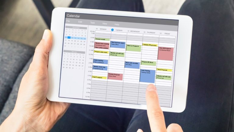 A person creates a team schedule on a tablet