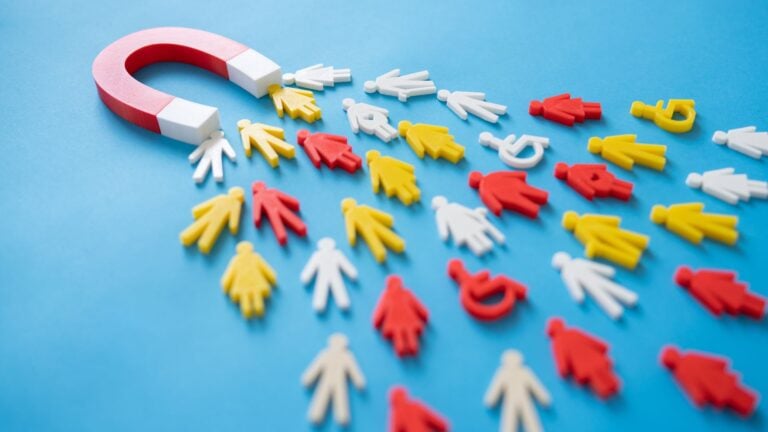 A magnet attracts little figurines to symbolize employee retention