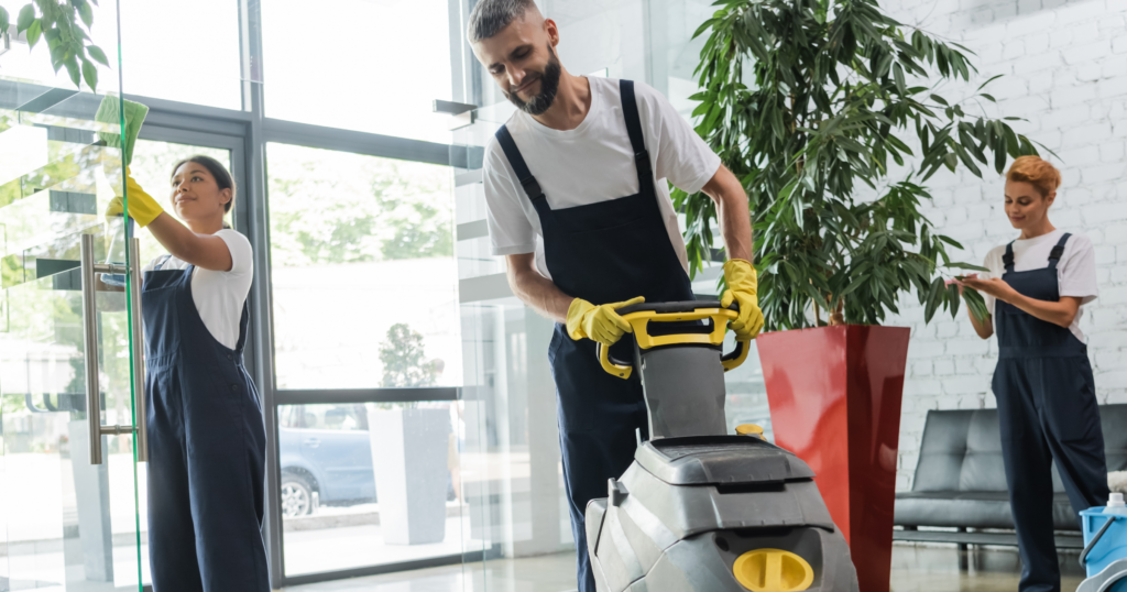 Image of three cleaners cleaning the inside of an office space