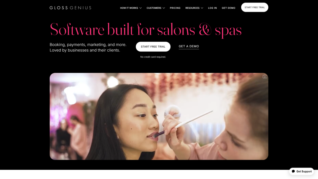 Screenshot of GlossGenius website homepage with an image of a makeup artist working on a client.