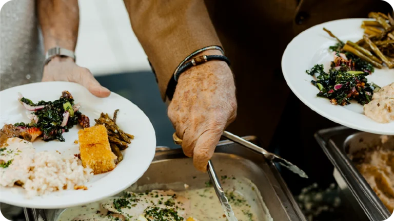 Catering staff serving plated meals buffet-style