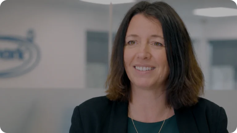 A smiling woman featured in a Connecteam training video testimonial.